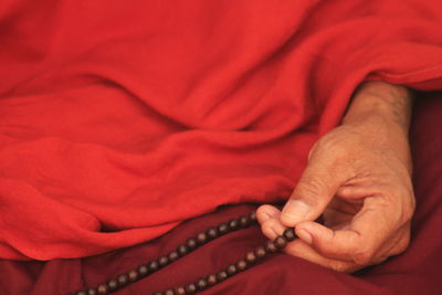 Midsection of man holding bead necklace