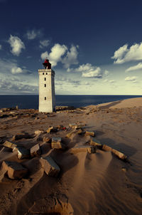 Rubjerg knude lighthouse at beach against sky