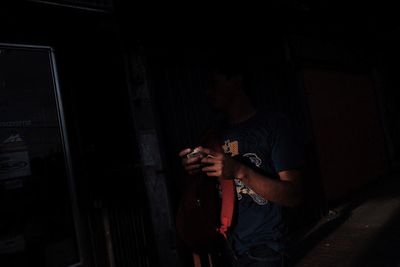 Young man holding camera at home