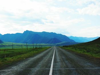 Empty road with mountains in background