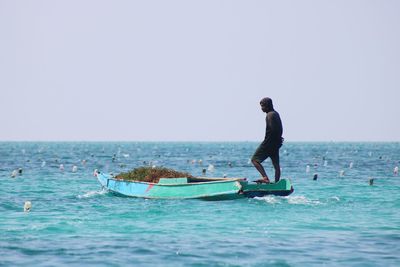 Man on sea against clear sky