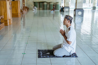 High angle view of man praying in mosque