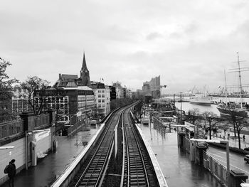 High angle view of railroad tracks by buildings against sky