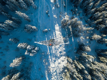 Directly above electrical pylon on snow covered land