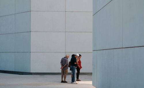 Full length of man and woman standing against building