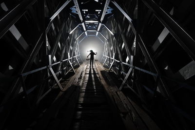 Rear view of silhouette man walking on staircase