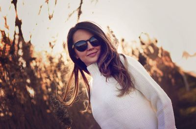 Portrait of young woman wearing sunglasses standing outdoors