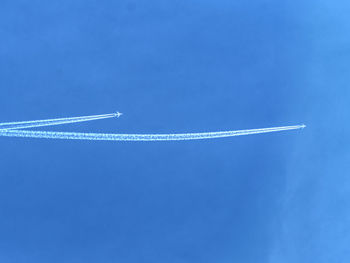 Crossing of airline lines on the blue sky above planet earth