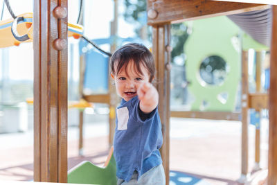 Portrait of cute boy pointing at playground