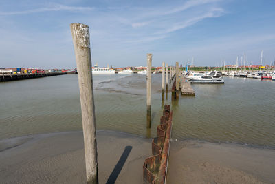 Boats moored at harbor against sky