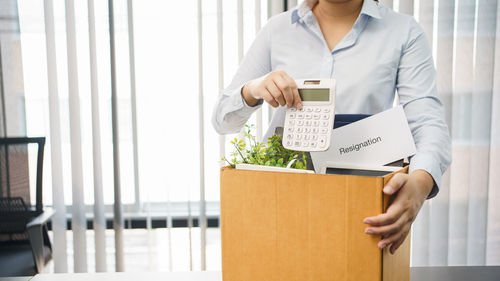 Midsection of woman holding box