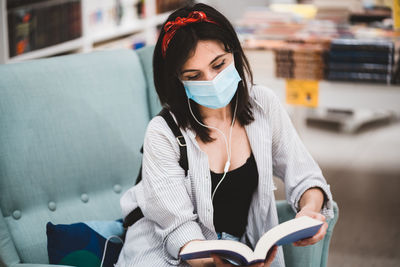 Full length of woman sitting on book