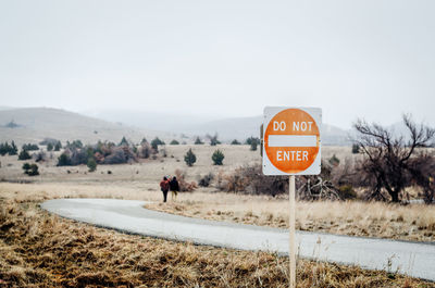 Close-up of no entry sign against country road