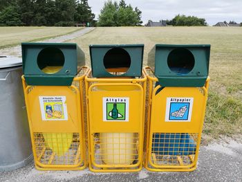 Yellow garbage bin on field