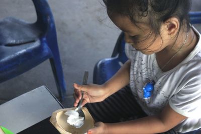 Side view of a girl eating coconut.