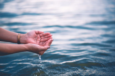 Midsection of person surfing in sea