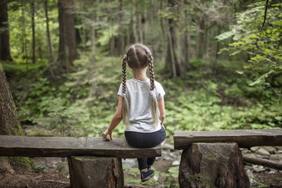 Full length of girl standing on wood in forest