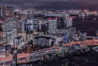 High angle view of illuminated cityscape against sky at night