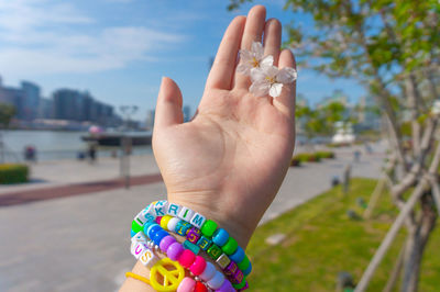 Close-up of hand holding multi colored against sky