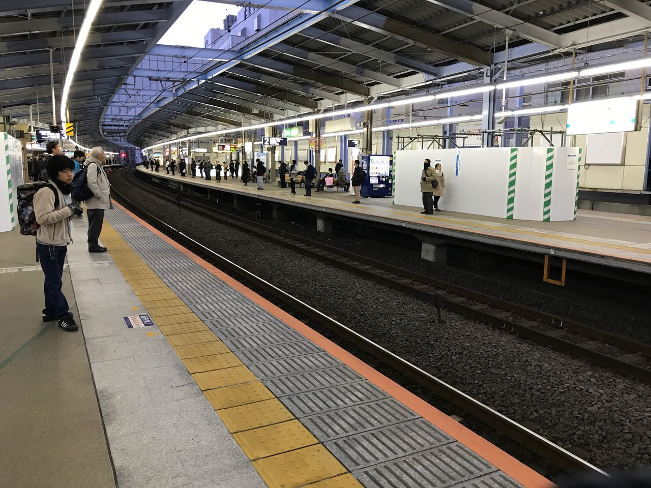 transportation, railroad station platform, public transportation, railroad track, railroad station, rail transportation, real people, train - vehicle, men, mode of transport, lifestyles, women, large group of people, passenger, journey, full length, indoors, commuter, standing, day, adult, people