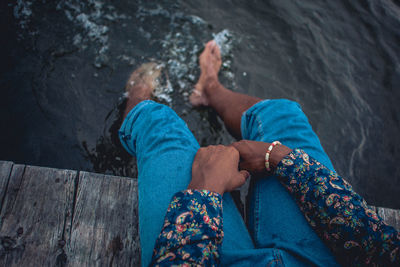 Low section of man sitting on jetty