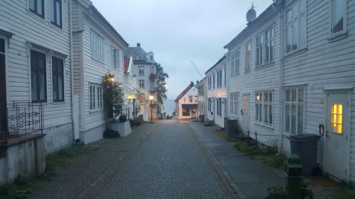 Road amidst buildings against sky