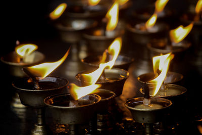 Close-up of lit candles in temple