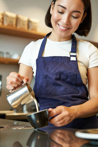 Midsection of woman working in kitchen