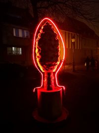 Illuminated light candles against wall at night