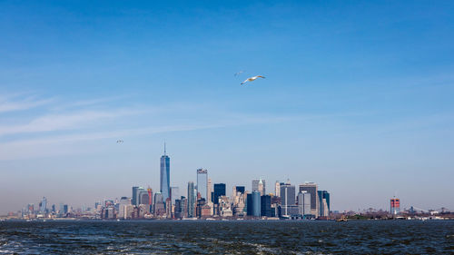 One world trade center in city against blue sky