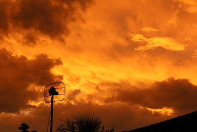 Low angle view of street light against dramatic sky