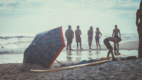 People on beach against sky