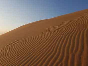 Sand dune in desert against clear sky