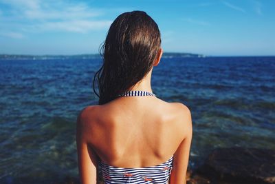 Rear view of young woman looking at sea