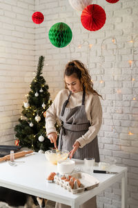 Smiling woman in the kitchen baking christmas cookies