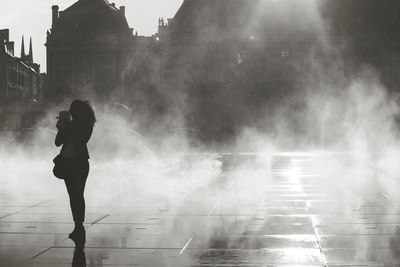 Rear view of silhouette woman standing in city