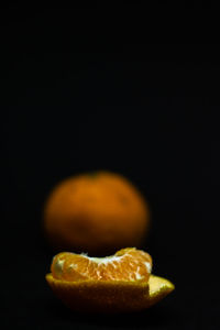 Close-up of orange slice over black background