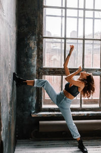 Full length of woman with arms raised window