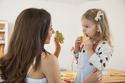 Mother and daughter with food on table at home
