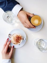 Directly above view of couple with coffee cups at table