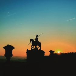 Low angle view of silhouette statue against sky during sunset