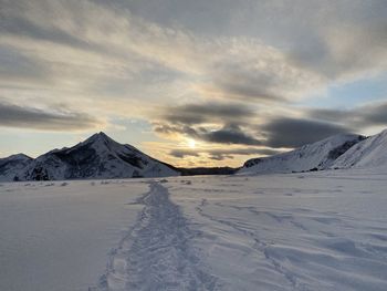 Scenic view of snowcapped mountains against sky during sunset