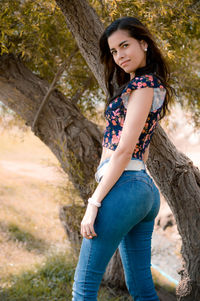 Portrait of young woman standing in forest