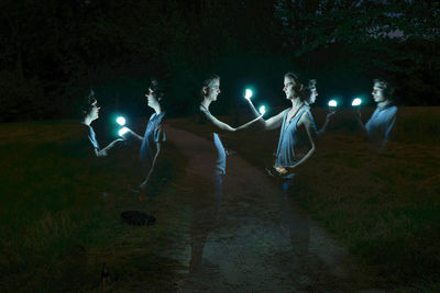 People on illuminated field at night