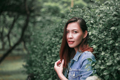 Portrait of woman standing against plants