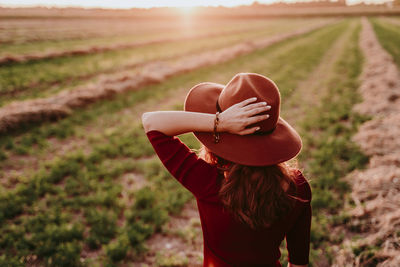 Rear view of woman wearing hat on field