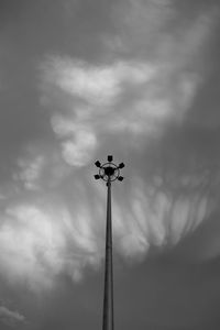 Low angle view of floodlight against cloudy sky