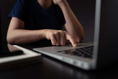 Midsection of man using laptop on table