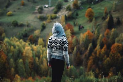 Rear view of woman standing on field during autumn