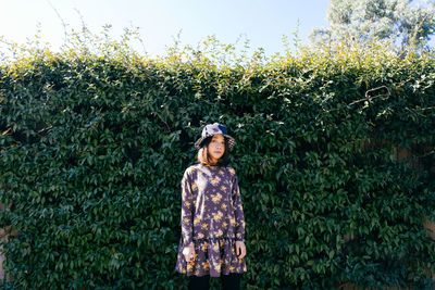 Portrait of mid adult woman standing against plants in park